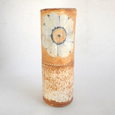 Cylindrical ceramic vase with floral design on a white background