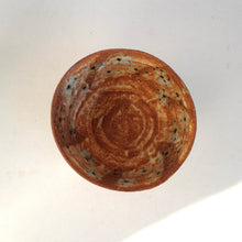 Brown ceramic bowl with floral pattern on a white background