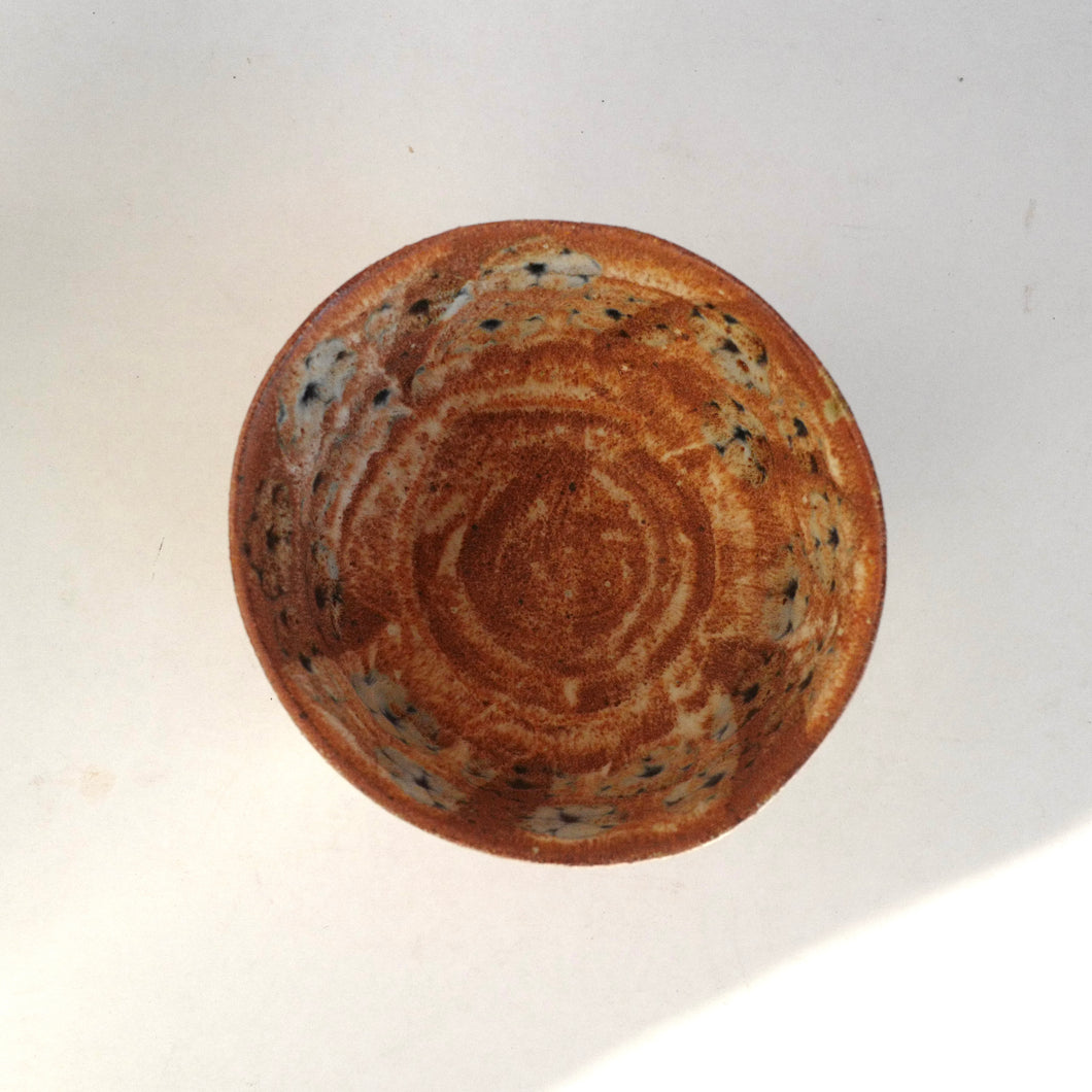 Brown ceramic bowl with floral pattern on a white background