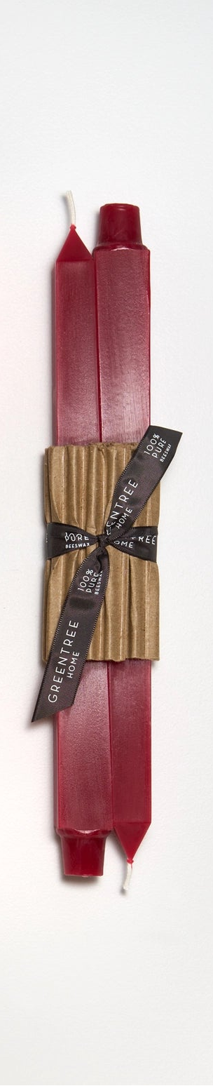 Set of two candles in bittersweet (red) color with brown paper wraps and brown ribbons on a white background