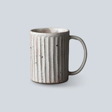 Gray ceramic mug with textured design on a light gray background