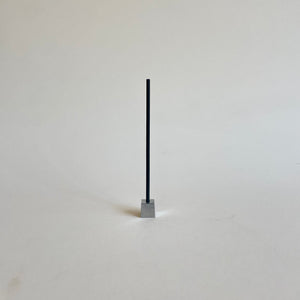 An Elemense Sekishin incense stick in a metal cube incense holder. 