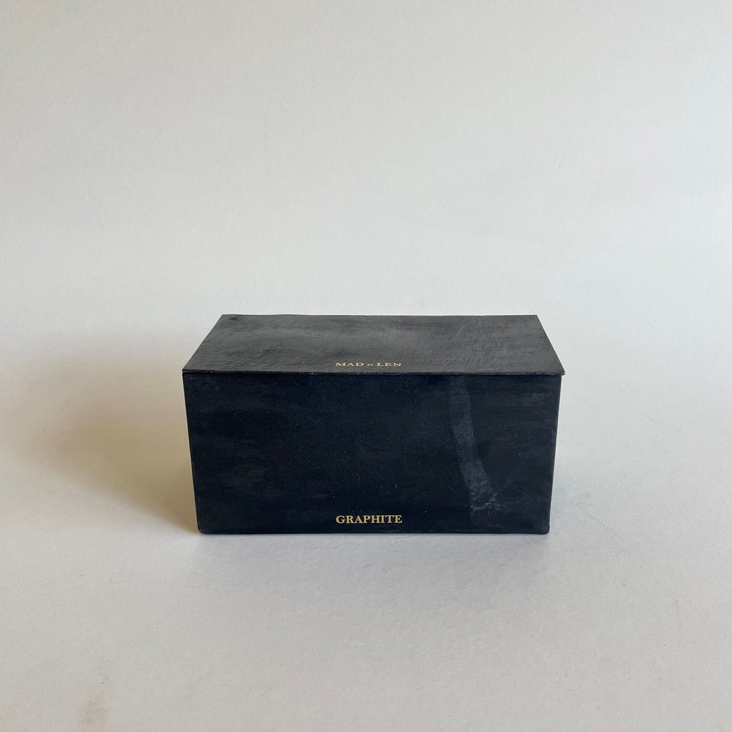 Black retangular shape Mad et Len Black Block Horizontal - Graphite candle. Box with gold lettering brand label. 
