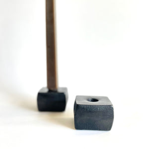 A pair of Iron candle Holder with one candle in one of the holders