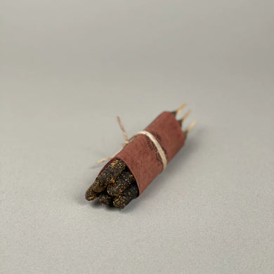 Incense sticks with brown wrapper on a gray background