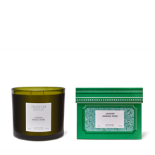 Green candle and packaging with 'Flamingo Estate' branding on a white background