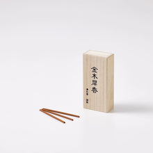 Wooden incense box with three sticks on a white background