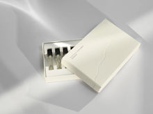 Set of perfume samples in a box on a light gray background