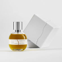 Perfume bottle with silver cap and white label on a light gray background