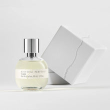 Perfume bottle with silver cap and white label on a light gray background
