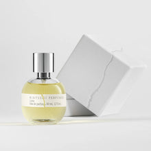 Perfume bottle with silver cap and white label on a light gray background