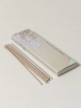 Incense sticks with their packaging on a light background