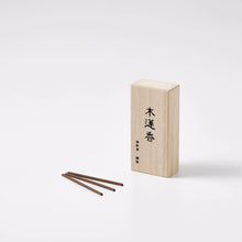 Wooden incense box with three sticks on a white background