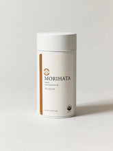 A white cylindrical canister of MORIHATA Organic Hojicha Leaf Green Tea on a light gray background.