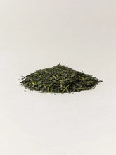 a pile of green tea leaves on white background