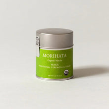 A small silver metal tin of Morihata Organic Matcha Waka Traditional Ceremonial Grade matcha tea, featuring a bright green label, set against a plain light gray background.