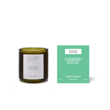 Green candle and packaging with 'Flamingo Estate' branding on a white background