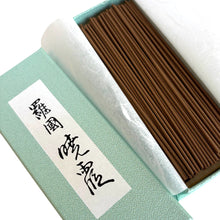 Incense sticks in a box with a green lid and white label on a white background