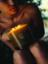 Close-up of a person holding a lit candle with a blurred background