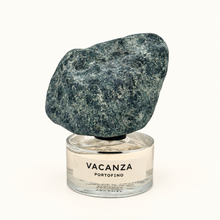 Vacanza Portofino perfume bottle with a large, rough, dark green-gray stone cap on a clean white background.