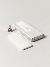 White rectangular box with a triangular incense clip on a light gray background