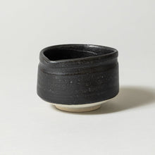 Black ceramic cup on a light gray background
