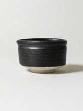 Black ceramic cup on a white background