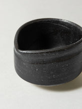 Black ceramic bowl on a light gray background