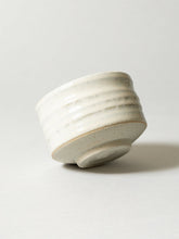 White ceramic bowl with grayish-brown accents on a light gray background
