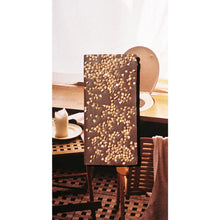 Decorative chocolate bar with a textured surface on a table with a candle