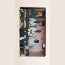 Chocolate bar packaging with three people in a room, featuring text and graphics.