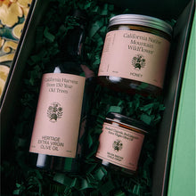 Bottle of California Harvest Extra Virgin Olive Oil and jars of California Native Mountain Flower Honey, and Salsa Macha in a gift box.
