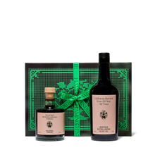 Two bottles of olive oil with a decorative green box with ribbon against a white background
