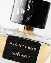 Close-up of a perfume bottle labeled 'Eight & Bob Guethary' with a black cap.