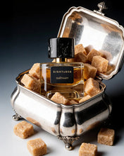 Perfume bottle with 'Eight & Bob' label in a decorative silver holder with brown sugar cubes.
