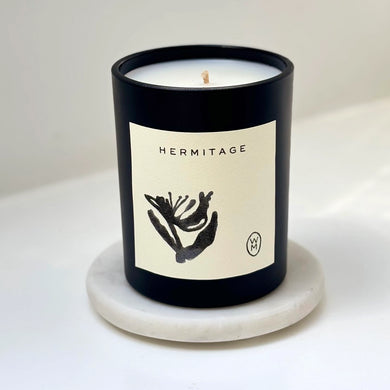 Candle with 'Hermitage' label on a white background