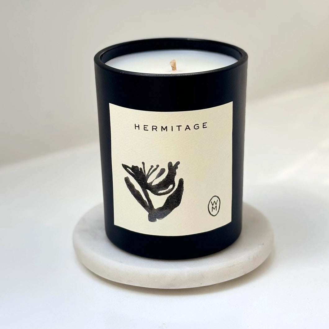 Candle with 'Hermitage' label on a white background