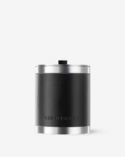 Black leather candle holder with silver lid on a white background