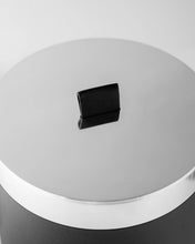 Close-up of a black knob on a white surface
