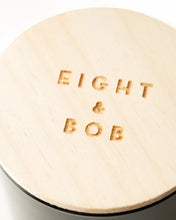 Round beige lid with 'EIGHT & BOB' embossed on it, on a white background
