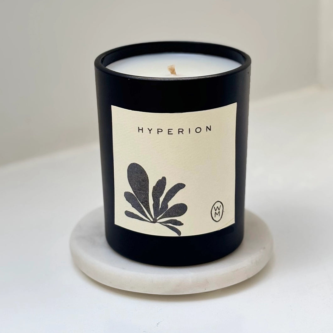 Candle with 'Hyperion' label on a marble coaster
