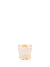 Small candle in a decorative glass holder on a white background