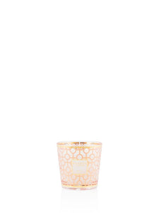 Small candle in a decorative glass holder on a white background