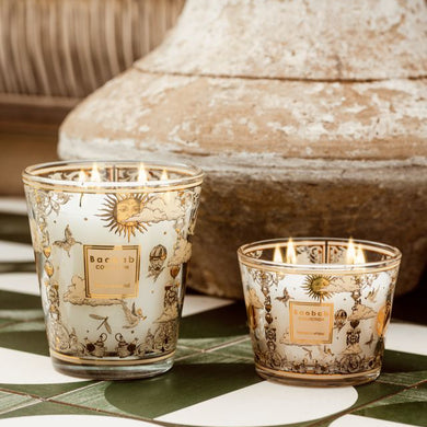 Two decorative candles with intricate designs on a tiled surface.