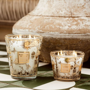 Two decorative candles with intricate designs on a tiled surface.