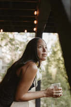 woman wearing "Buenos Tiempos" with a drink