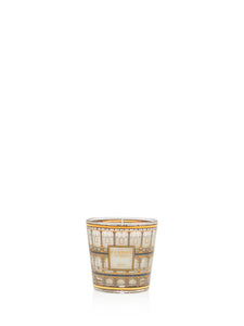 Decorative candle in a glass holder with intricate design on a white background