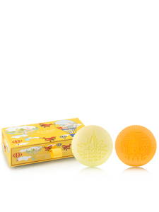 Two yellow bath soaps and their packaging on a white background