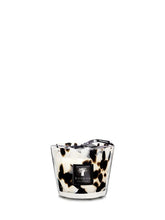 Candle with a black and white pattern in a glass holder on a white background