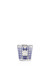 Candle in a glass container with blue geometric pattern on a white background